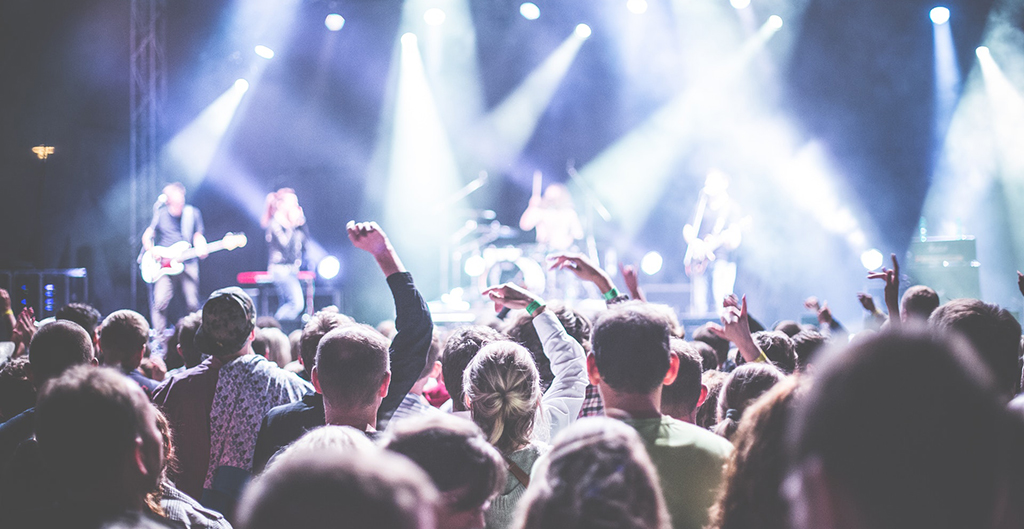 Photo of a music festival crowd jumping around facing the stage